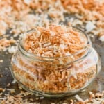 a small mason jar full of toasted coconut on a tray with more toasted coconut - 9