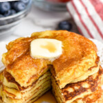pinterest graphic of stack of yogurt pancakes with butter and syrup on top, a wedge cut out of them, says "the best yogurt pancakes simplejoy.com"