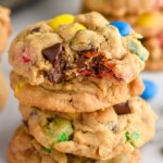Close up photo of a stack of Monster Cookies with a bite taken out of the top cookie.
