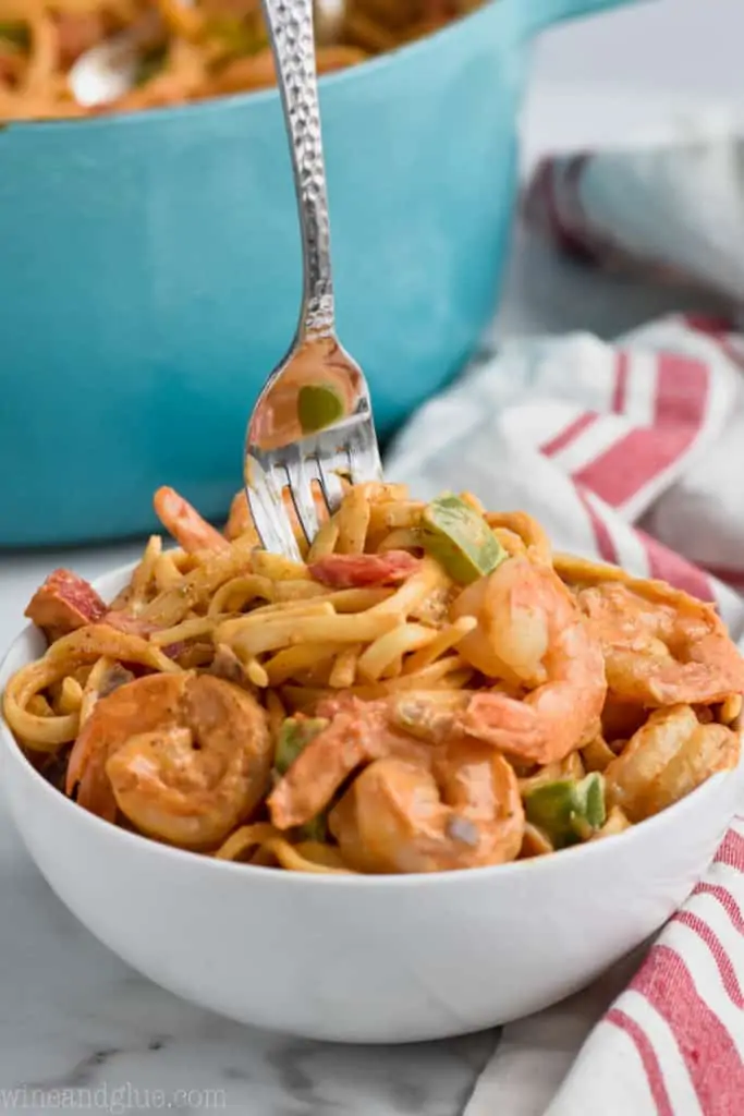 for in a bowl of tasty one pot shrimp fajita pasta with a fork coming out