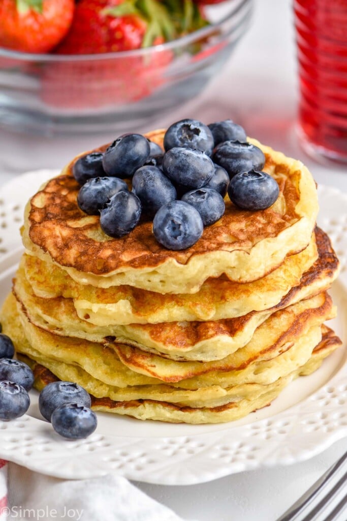 angled view of stack of pancakes made with yogurt with blueberries on top
