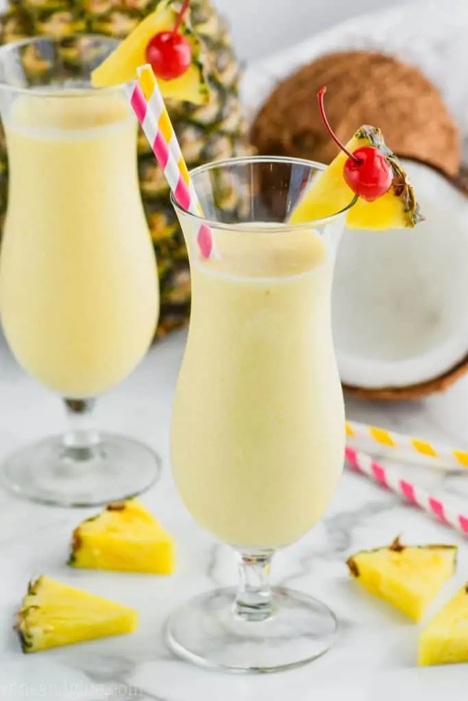 hurricane glass filled with an easy pina colada garnished with a pineapple