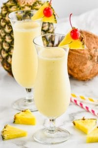hurricane glass filled with an easy pina colada garnished with a pineapple