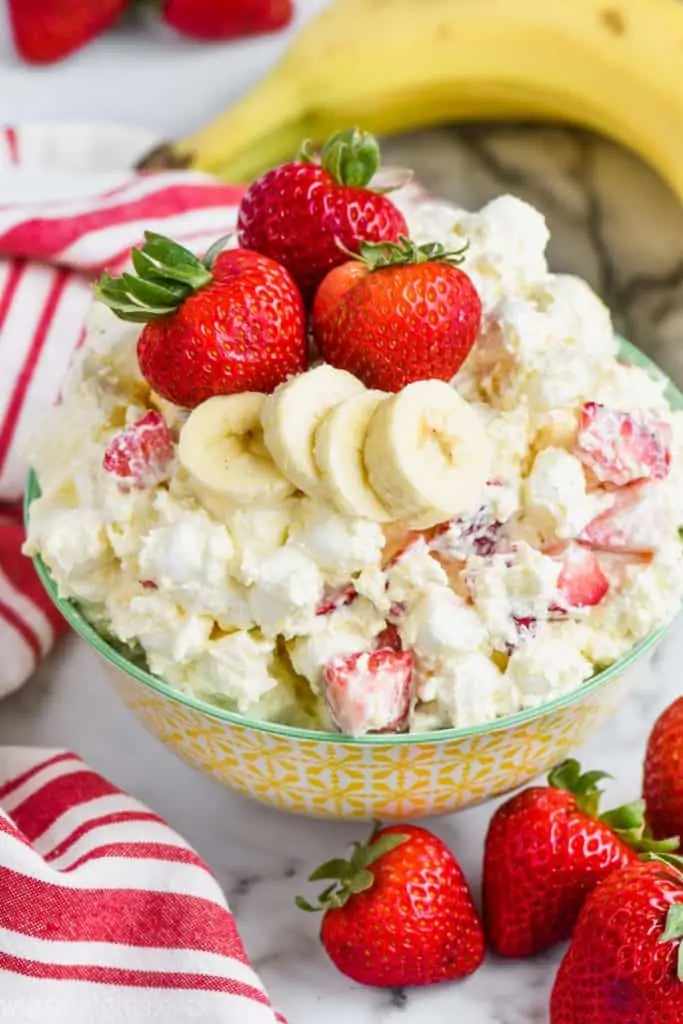 overhead view of strawberry banana fluff recipe in a bowl with fresh strawberries and bananas