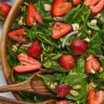 overhead view of strawberry spinach salad in wooden bowl