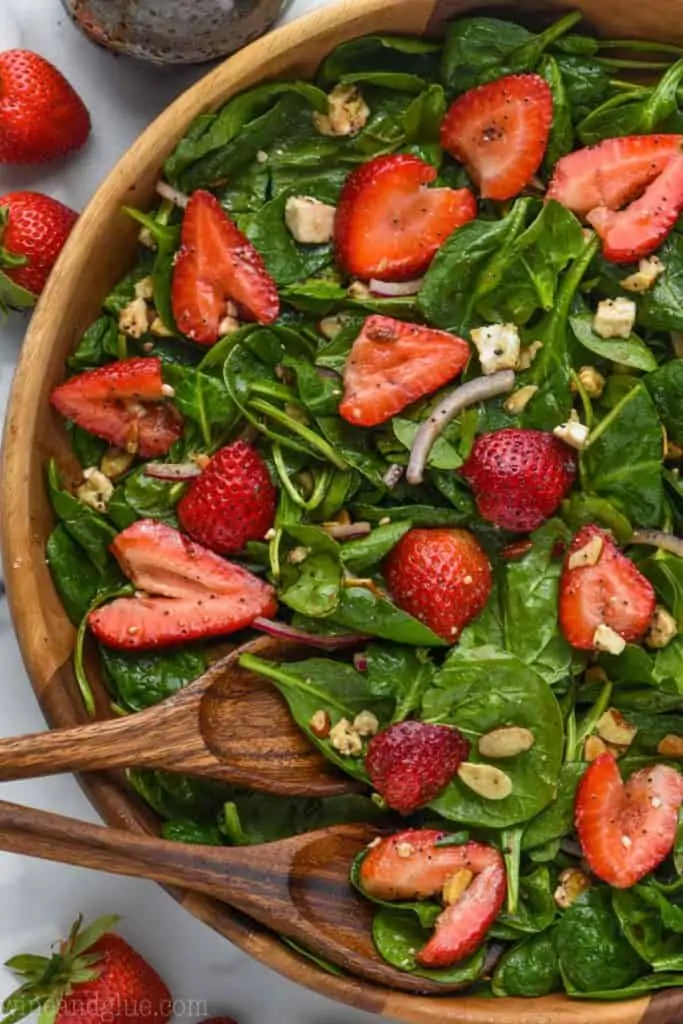 overhead view of strawberry spinach salad in wooden bowl