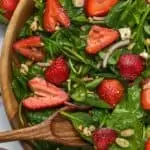 overhead view of strawberry spinach salad in wooden bowl