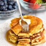 stack of yogurt pancakes with a cut made into them, and a fork digging in