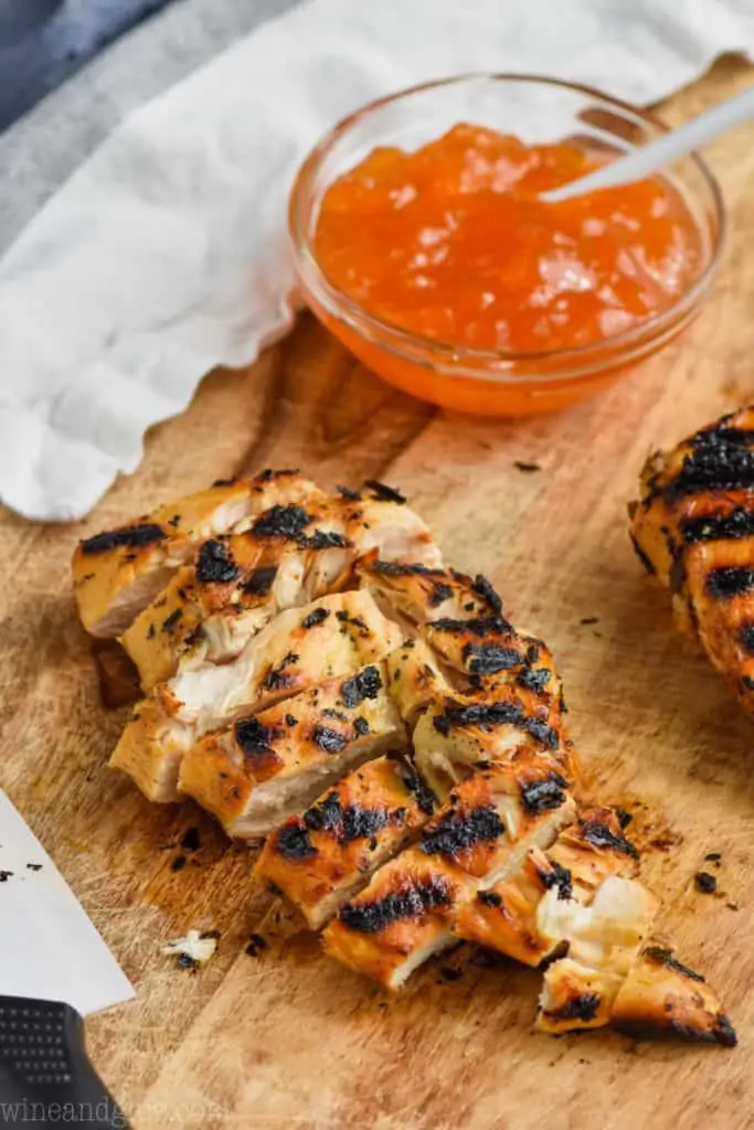 piece of grilled chicken cut up, and in the background is of Apricot Mustard Marinade