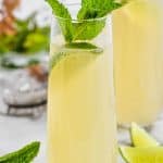 stemless champagne flute with champagne moscow mule, garnished with mint leaves and a lime wedge - 7