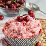 a bowl of cherry cheesecake fluff topped with fresh cherries