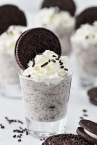up close shot of a cookies and cream pudding shot garnished with whipped cream and an oreo cookie