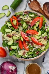 overhead view of greek orzo pasta salad with tomatoes, cucumbers, red onion, orzo and spinach