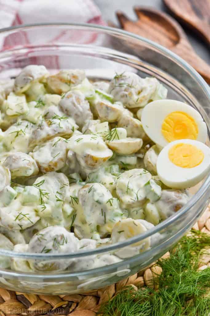 big serving bowl full of healthy potato salad topped with dill