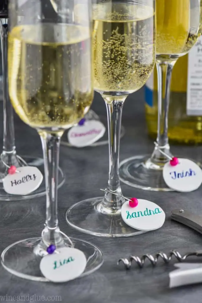 diy wine charms hanging off of champagne glasses