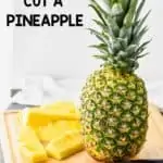 a whole pineapple on a cutting board waiting t be cut