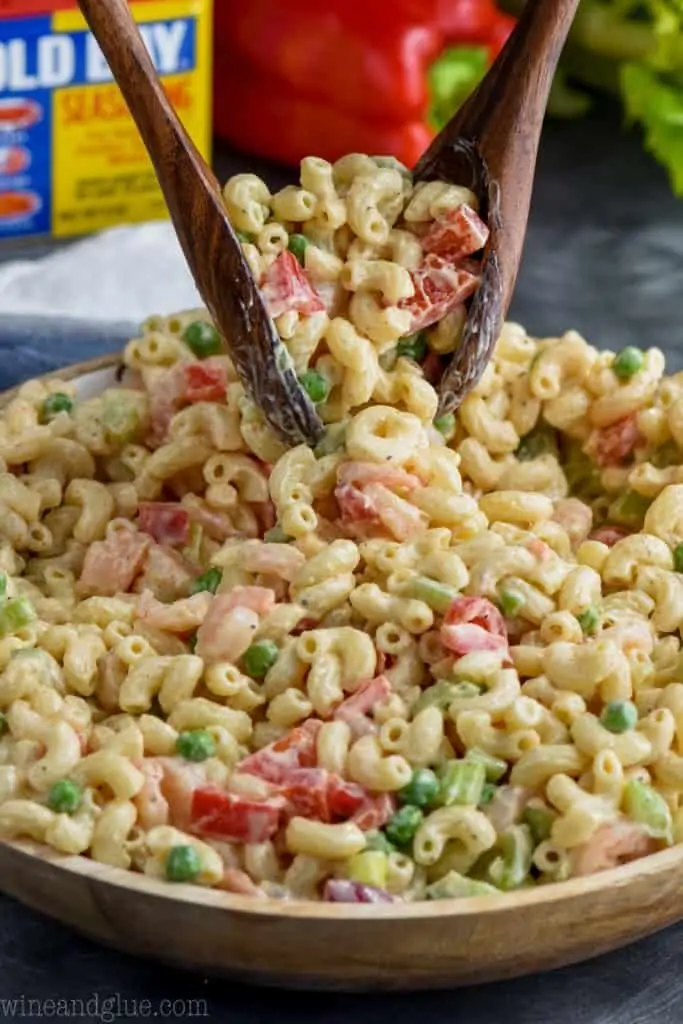 scooping the best cold shrimp pasta salad out of a serving bowl