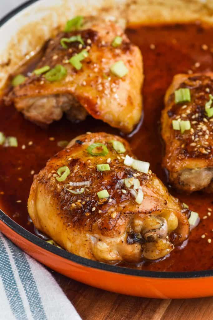 In a pan, three Honey Garlic Chicken topped with sesame and chives. 
