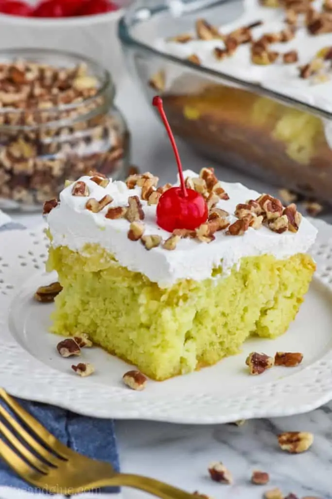 watergate cake recipe on a plate topped with walnuts and a cherry