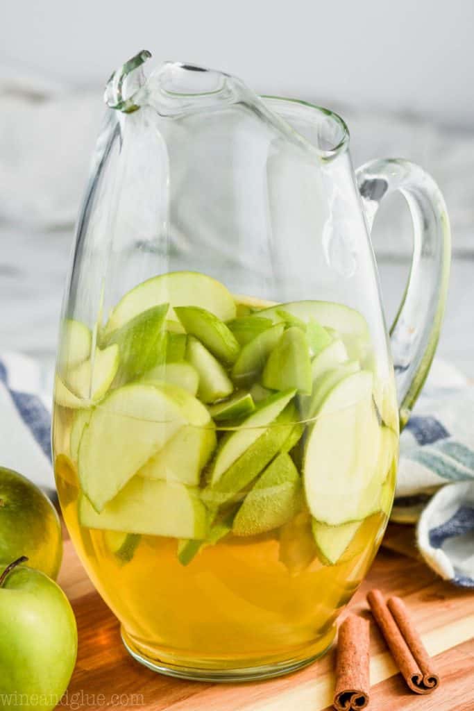 pitcher of apple pie sangria with cut up green apples