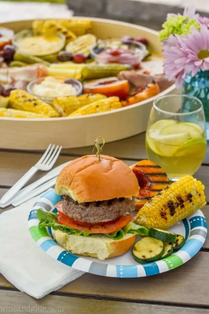burger and grilled sides on a paper plate