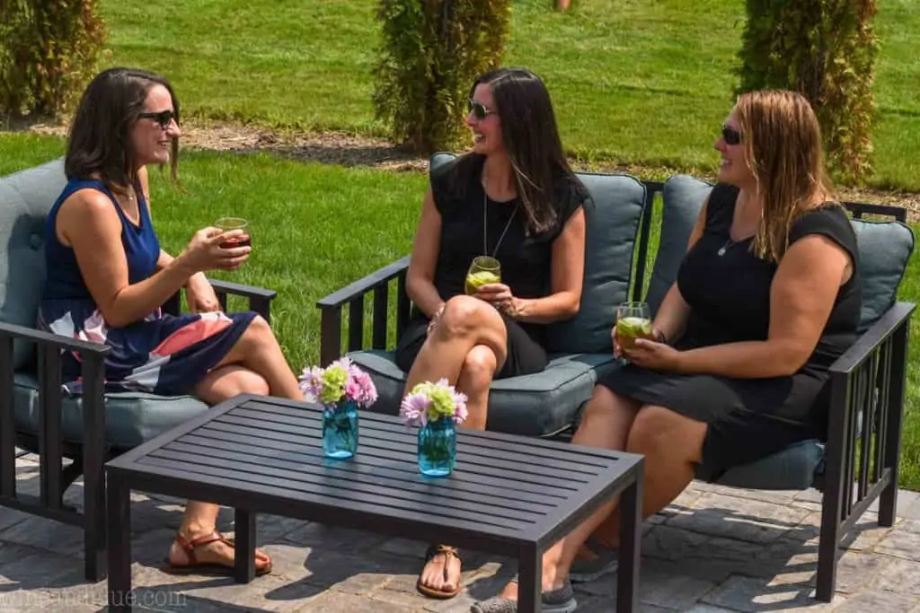 three women sharing wine at labor day party