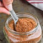 the best cajun seasoning recipe in a mason jar being spooned out
