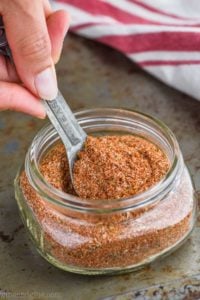 the best cajun seasoning recipe in a mason jar being spooned out