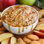 bowl of caramel apple dip recipe dripping from the sides with caramel sauce