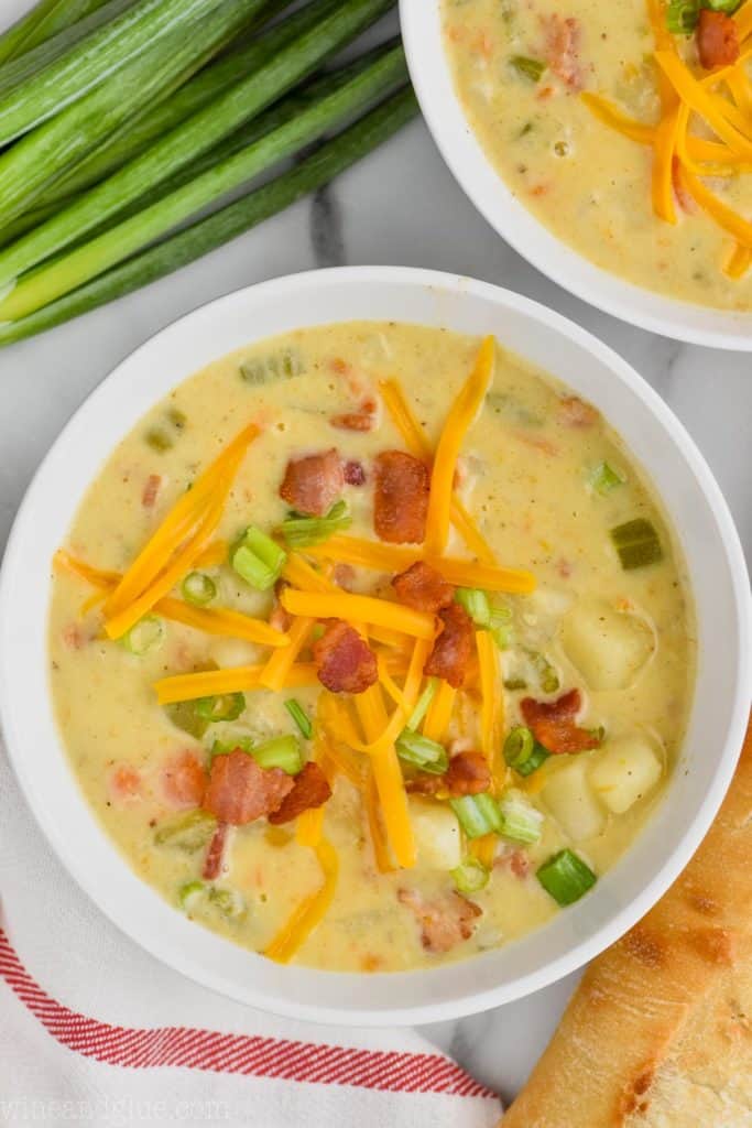 overhead view of easy creamy potato soup with cheese, bacon, and scallions