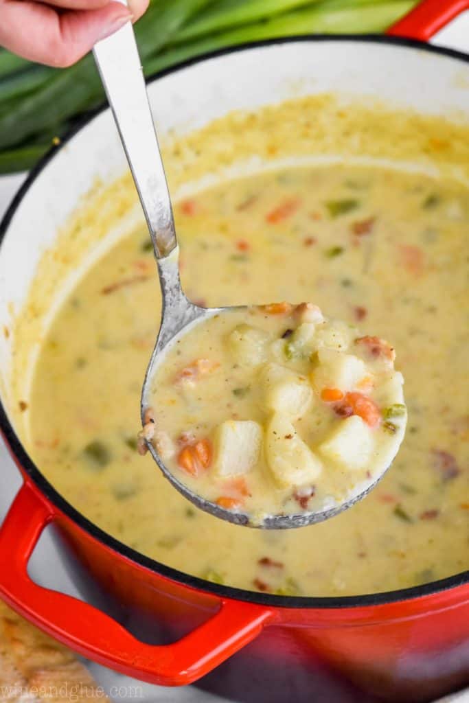 easy creamy potato soup being ladled out of a stock pot