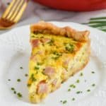 ham and cheese quiche recipe on a plate with chives