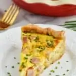 ham and cheese quiche recipe on a plate with chives