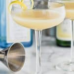 glass with saketini cocktail recipe in front of a bottle of gin and a bottle of sake - 13