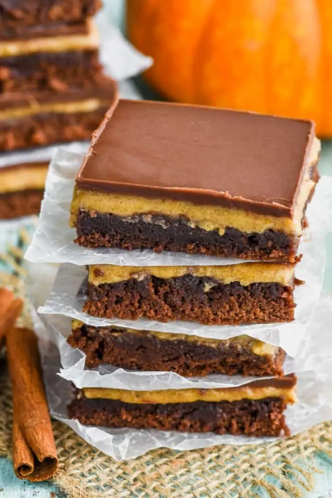 stack of pumpkin brownies with parchment paper underneath each one