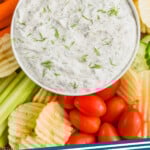 pinterest graphic of over head of dill vegetable dip recipe with chips and vegetables, says: the best dill dip simplejoy.com