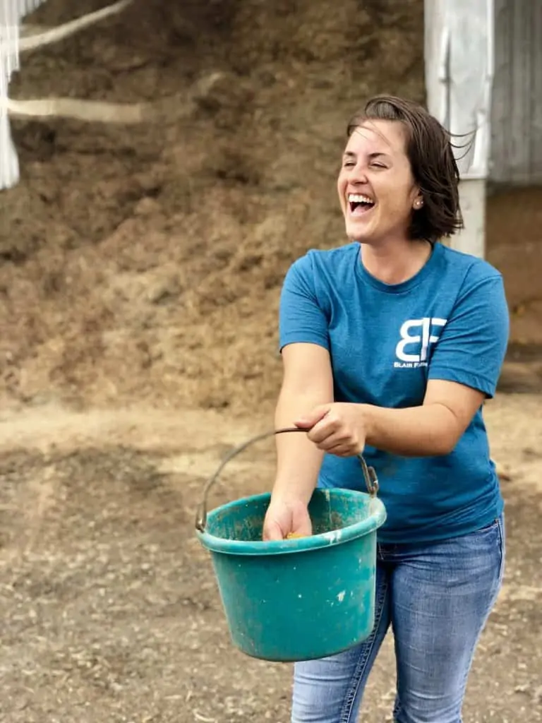 A woman holding a blue green bucket 