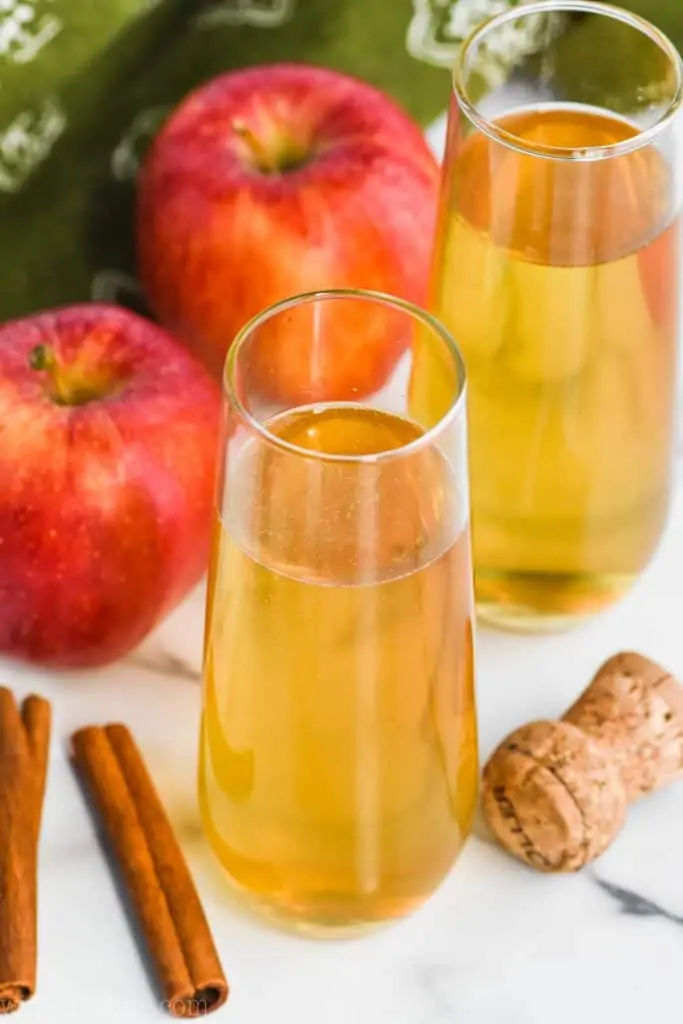 champagne pouring into a glass of bellini drink recipe