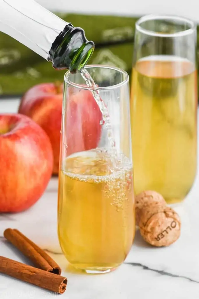 champagne pouring into a glass of bellini drink recipe