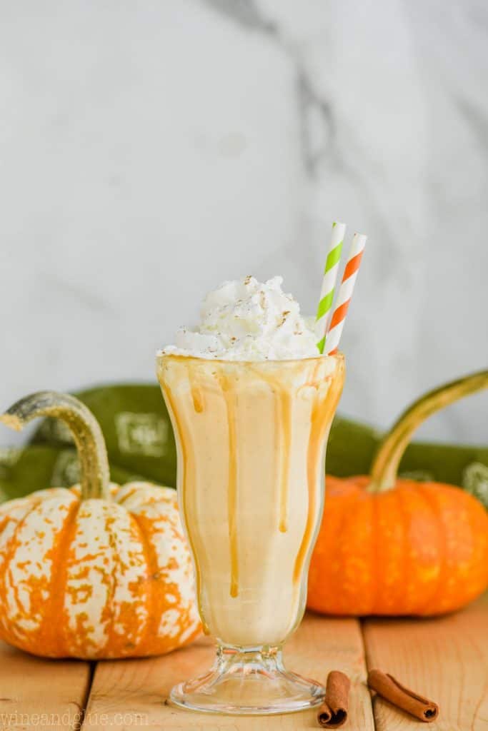 boozy pumpkin milkshake with whipped cream and straws