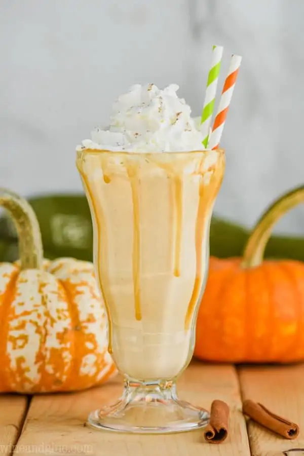 boozy pumpkin milkshake with whipped cream and straws