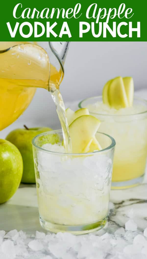 cup of caramel apple vodka punch garnished with sliced apples