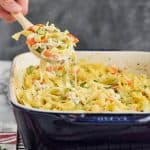 spoon digging into a cheesy chicken and noodle casserole recipe