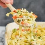 spoon digging into a cheesy chicken and noodle casserole recipe
