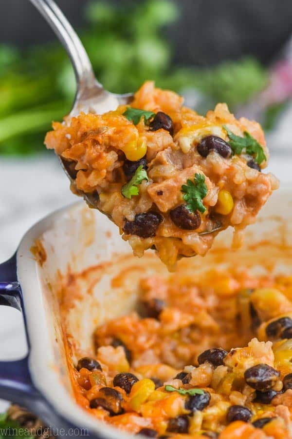 up close of southwestern chicken rice casserole recipe being spooned out of baking dish