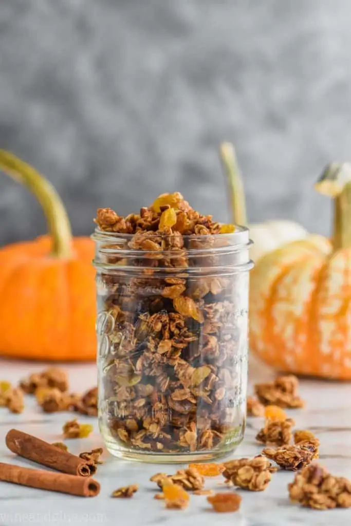 mason jar full of granola recipe with pumpkins in the background