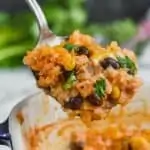 up close of southwestern chicken rice casserole recipe being spooned out of baking dish