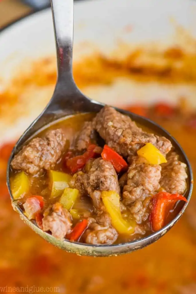 ladle of steak fajita soup recipe with red and yellow peppers and steak