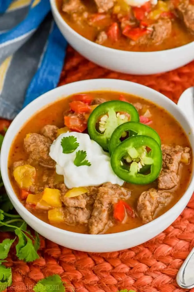 bowl of steak fajita soup recipe topped with sour cream, cilantro, and jalapeños 