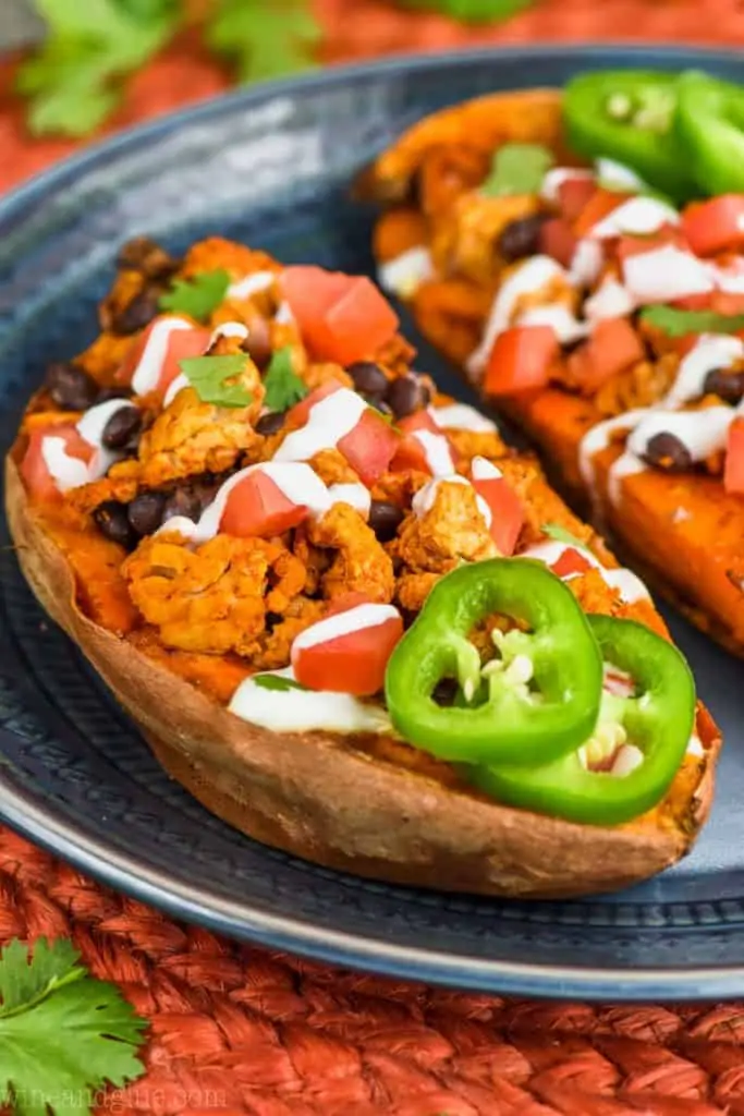 stuffed sweet potatoes garnished with taco fixings on a plate